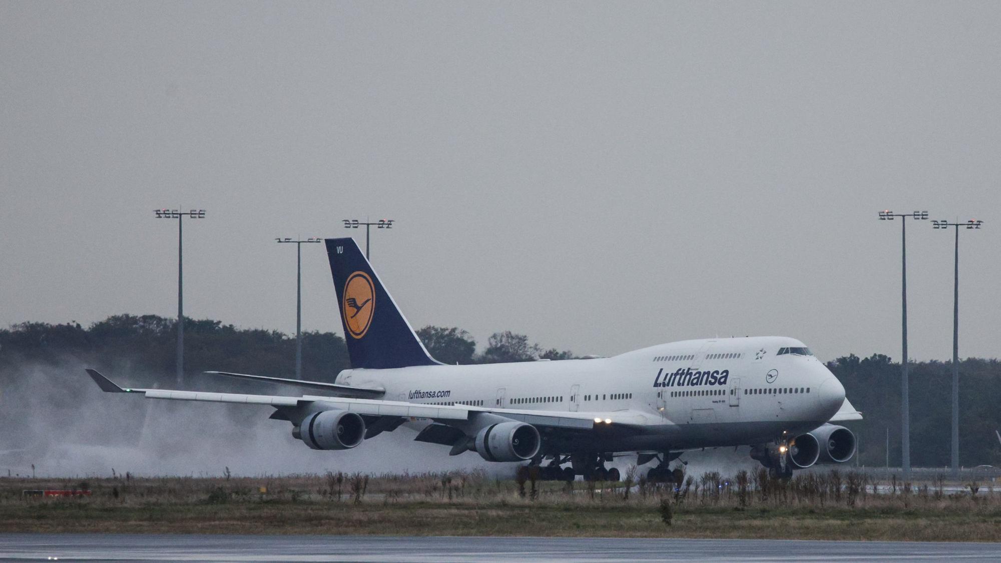 Eine Boeing 747 der deutschen Fluggesellschaft Lufthansa im Landeanflug bei einem Unwetter. Der Regen auf der Landebahn wird aufgewirbelt. (Symbolbild)
