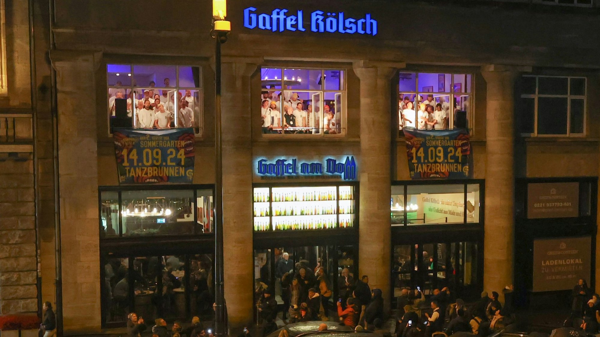 Zu sehen ist das Adventsfensterkonzert der Grüngürtelrosen
an der Domstube Gaffel am Dom