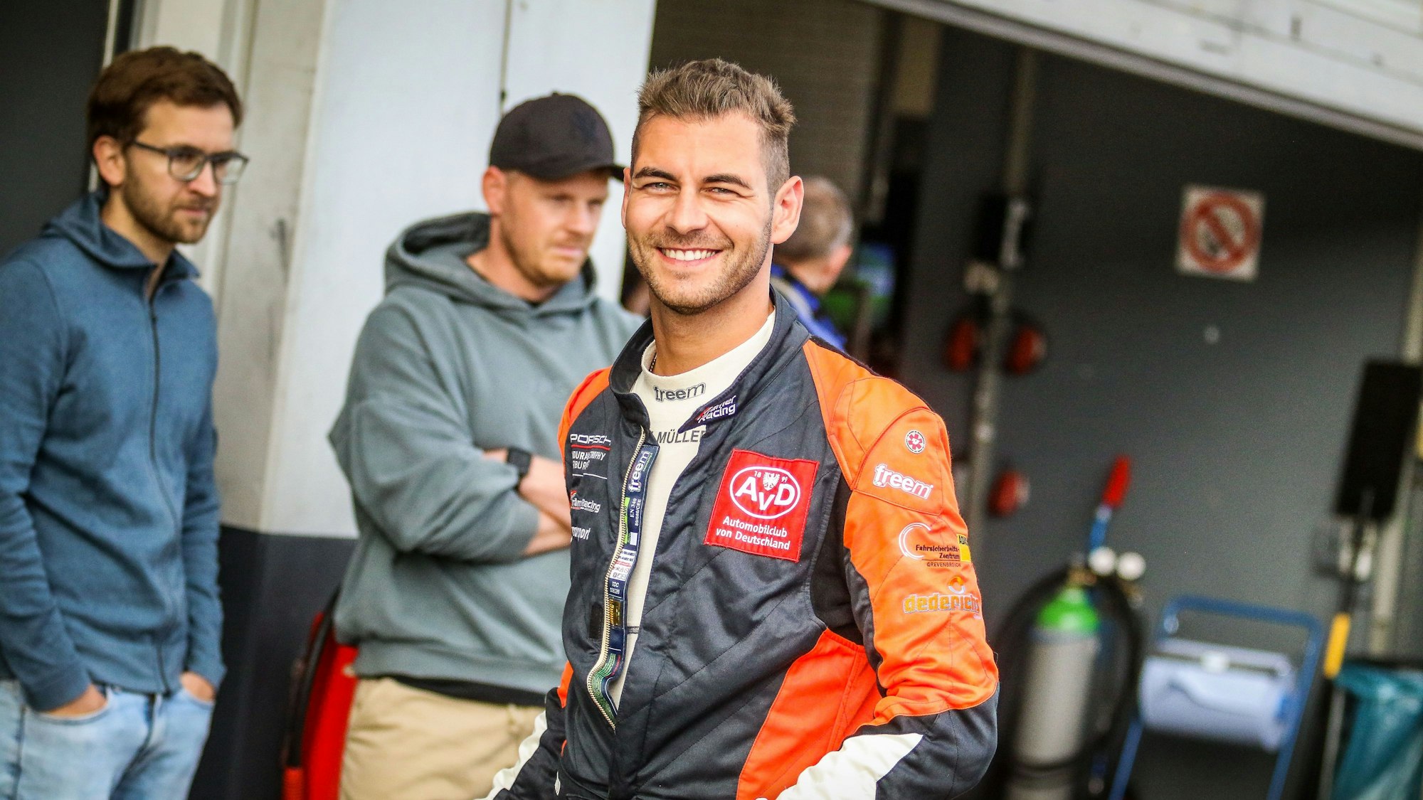 Das Bild zeigt Tobias Müller in der Boxengasse am Nürburgring. Er lächelt in die Kamera.