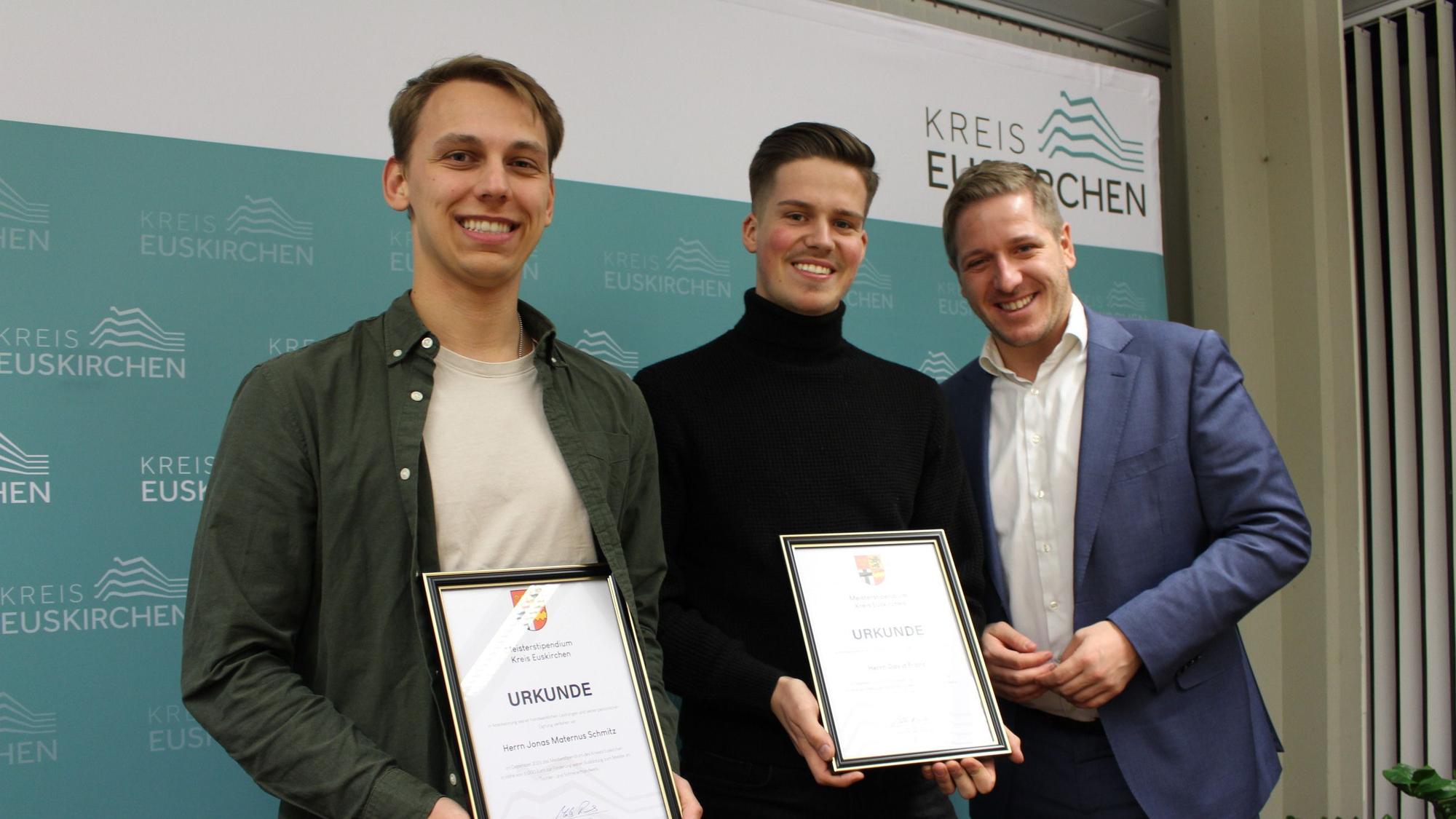 Jonas Maternus Schmitz und David Franz zeigen ihre Urkunden, daneben steht Landrat Markus Ramers.