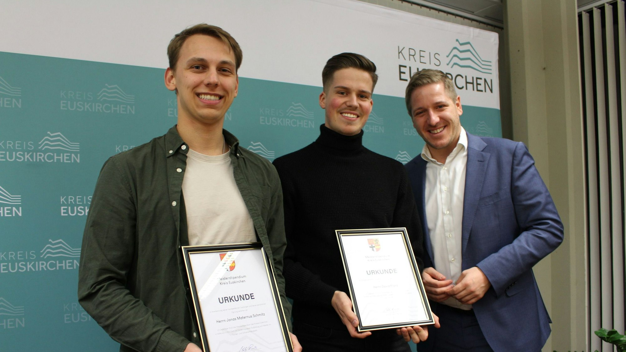 Jonas Maternus Schmitz und David Franz zeigen ihre Urkunden, daneben steht Landrat Markus Ramers.