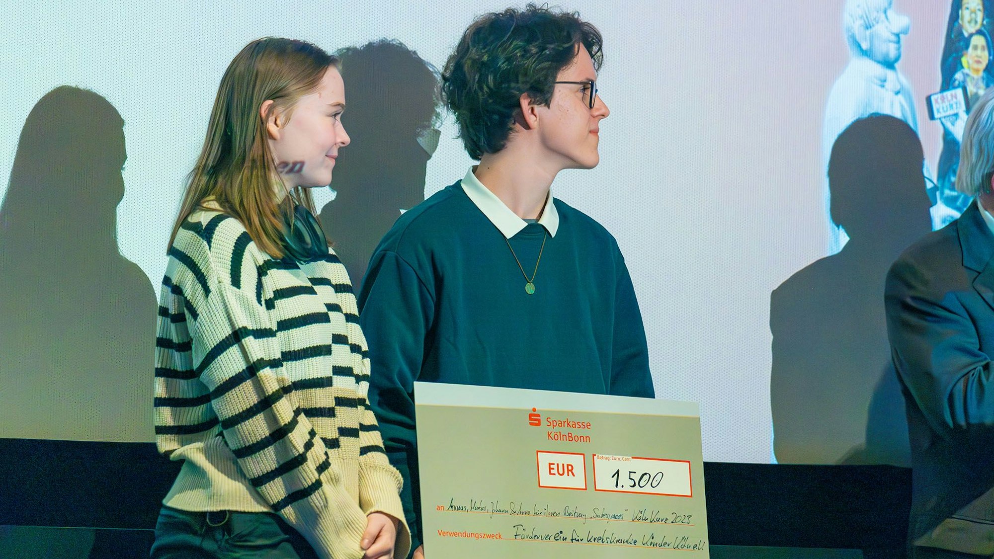 Anna und Arnas nehmen das Preisgeld für den ersten Platz in der Alterskategorie „13 – 15 Jahre“ entgegen.