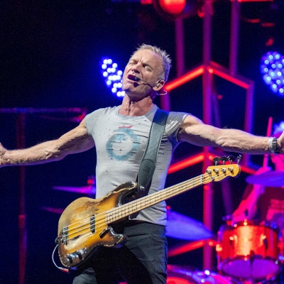 Sting breitet die Arme aus, er hat die Augen gescbhlossen und singt.