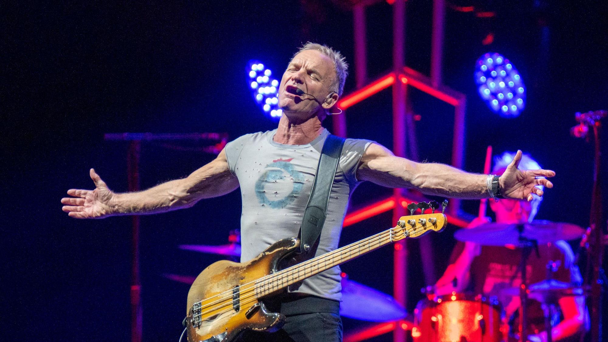 Sting breitet die Arme aus, er hat die Augen gescbhlossen und singt.
