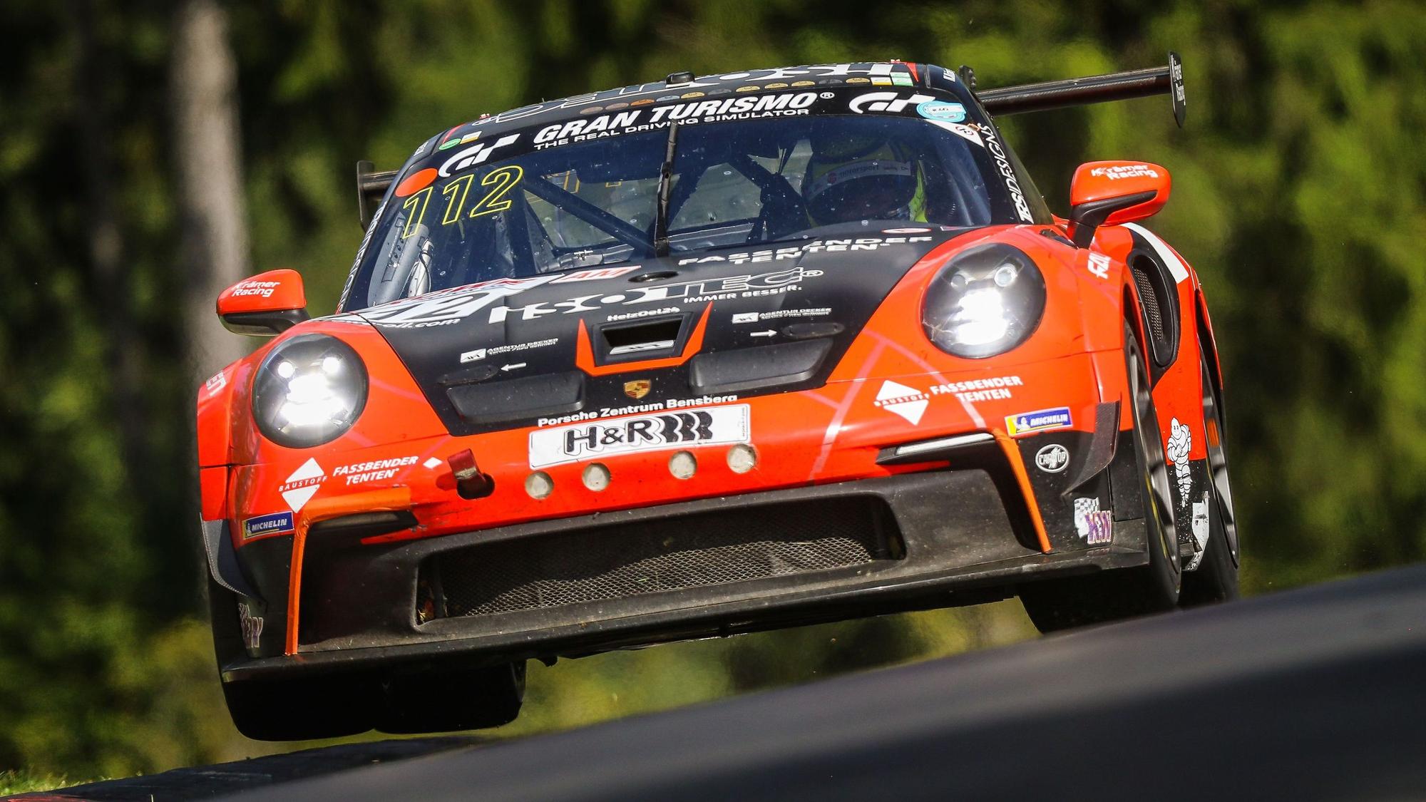 Das Bild zeigt einen rot-schwarzen Porsche auf dem Nürburgring. Am Steuer sitzt Tobias Müller.