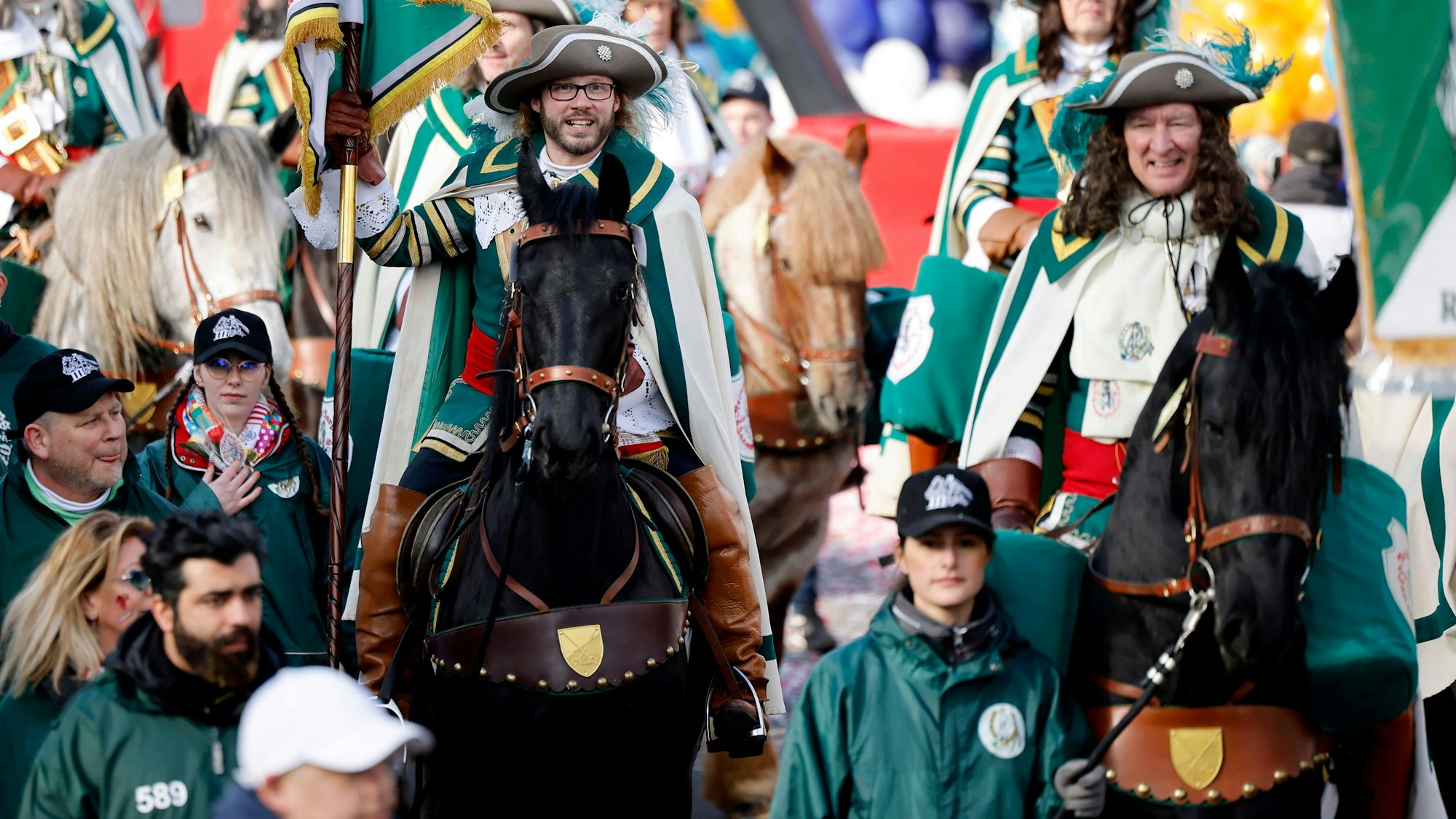 Pferde, Jecken und kostümierte Narren auf dem Rosenmontagszug 2023 in Köln.