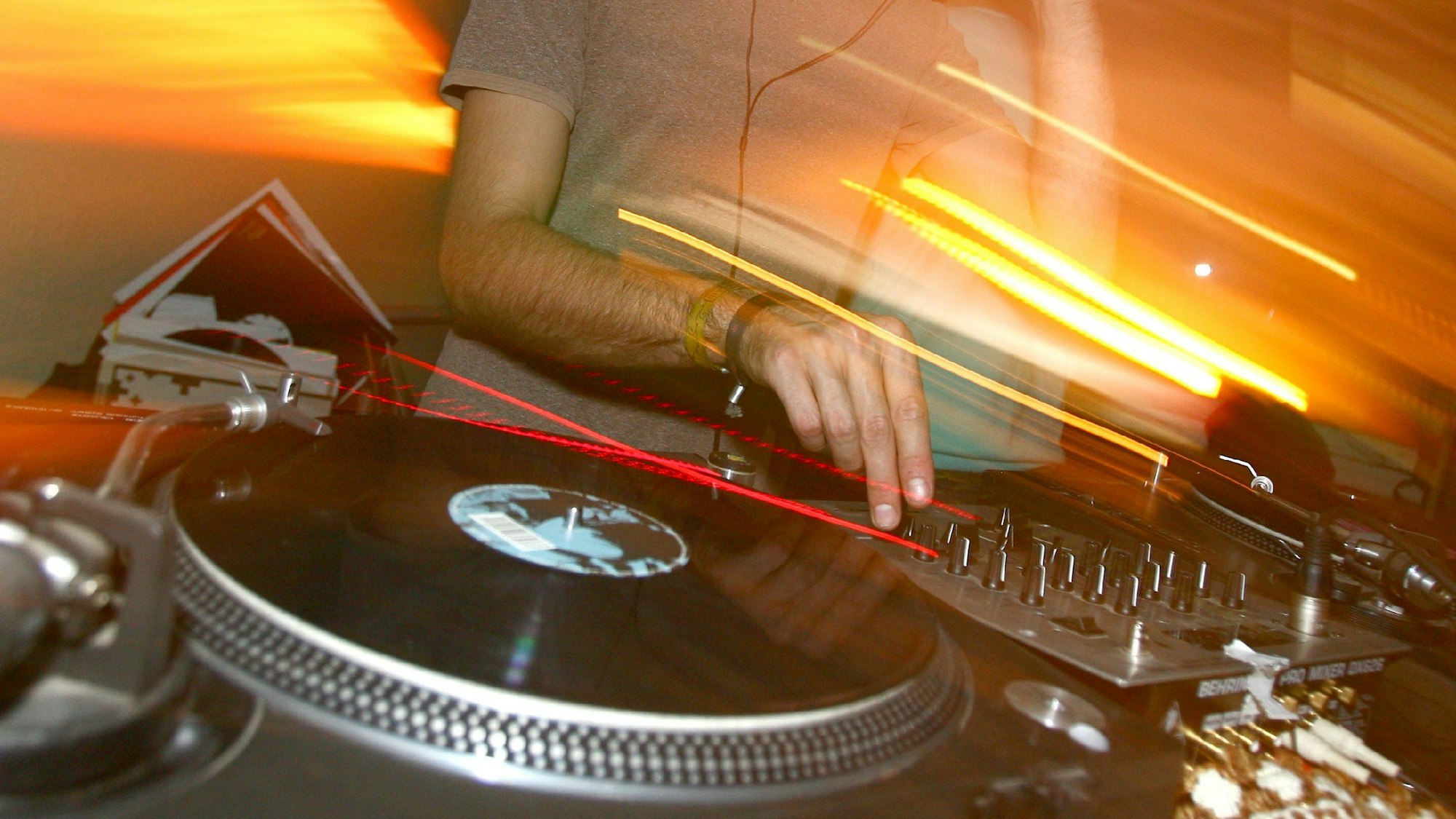 Ein DJ steht an einem Mischpult.