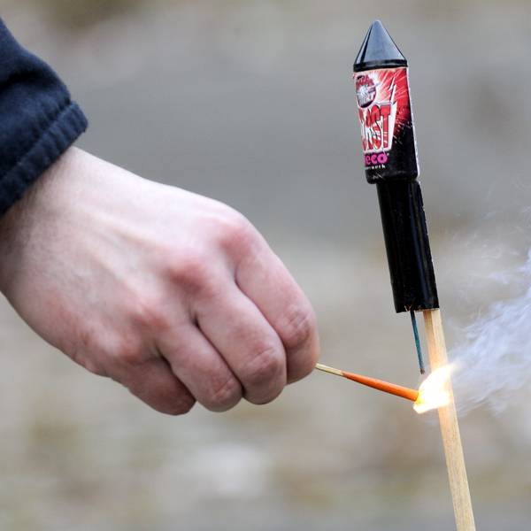 Ein Mann zündet die Zündschnur einer Silvesterrakete an. Feuerwehr und Polizei warnen vor leichtfertigem Umgang mit Böllern in der Silvesternacht.