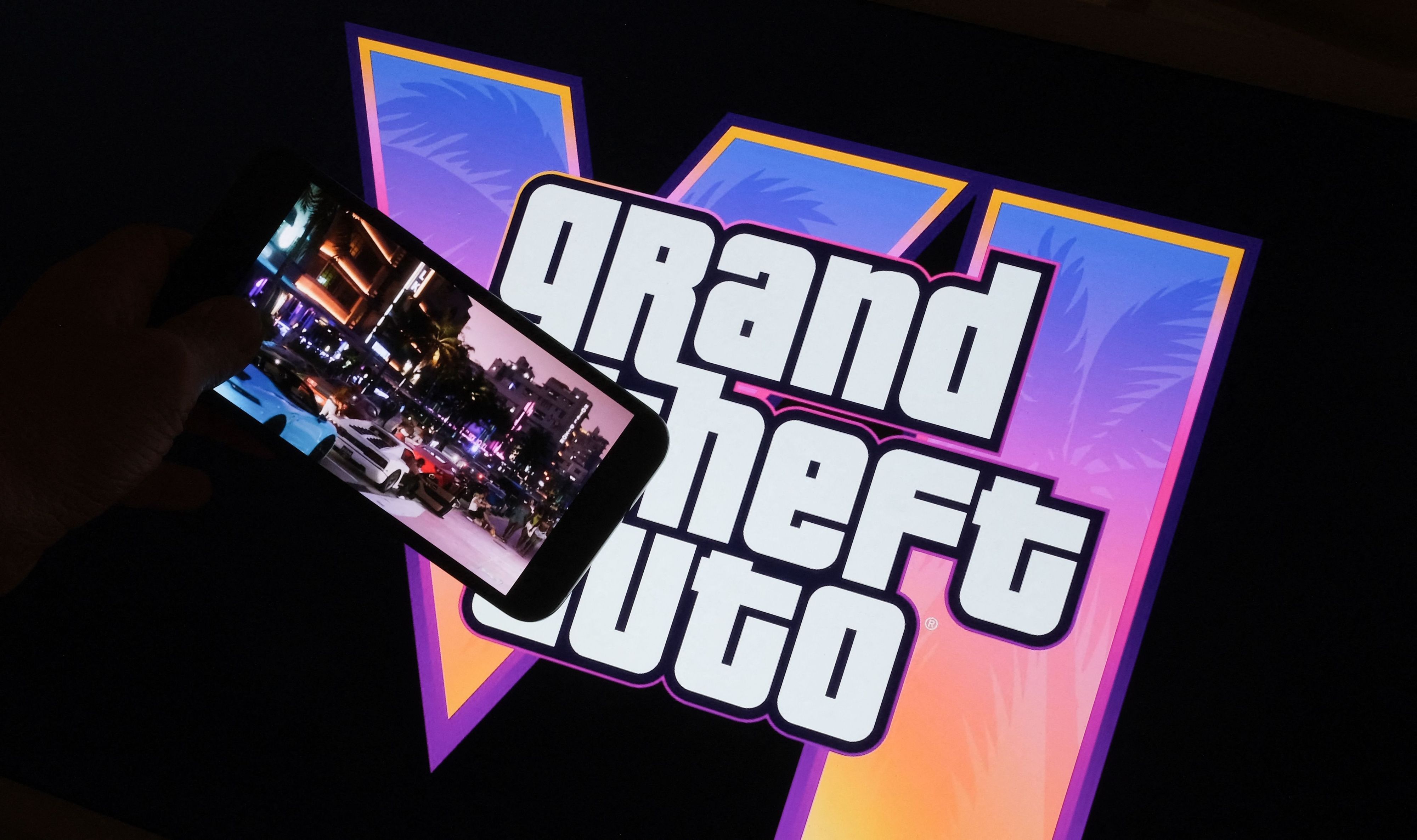 This illustration photo created in Los Angeles, December 4, 2023, shows Rockstar Games Grand Theft Auto VI trailer played on a screen in front of the game title. The first trailer for "Grand Theft Auto VI" was officially released ahead of schedule December 4, 2023 due to a leak, touting a 2025 release for the next chapter of the massively successful video game franchise. (Photo by Chris DELMAS / AFP)