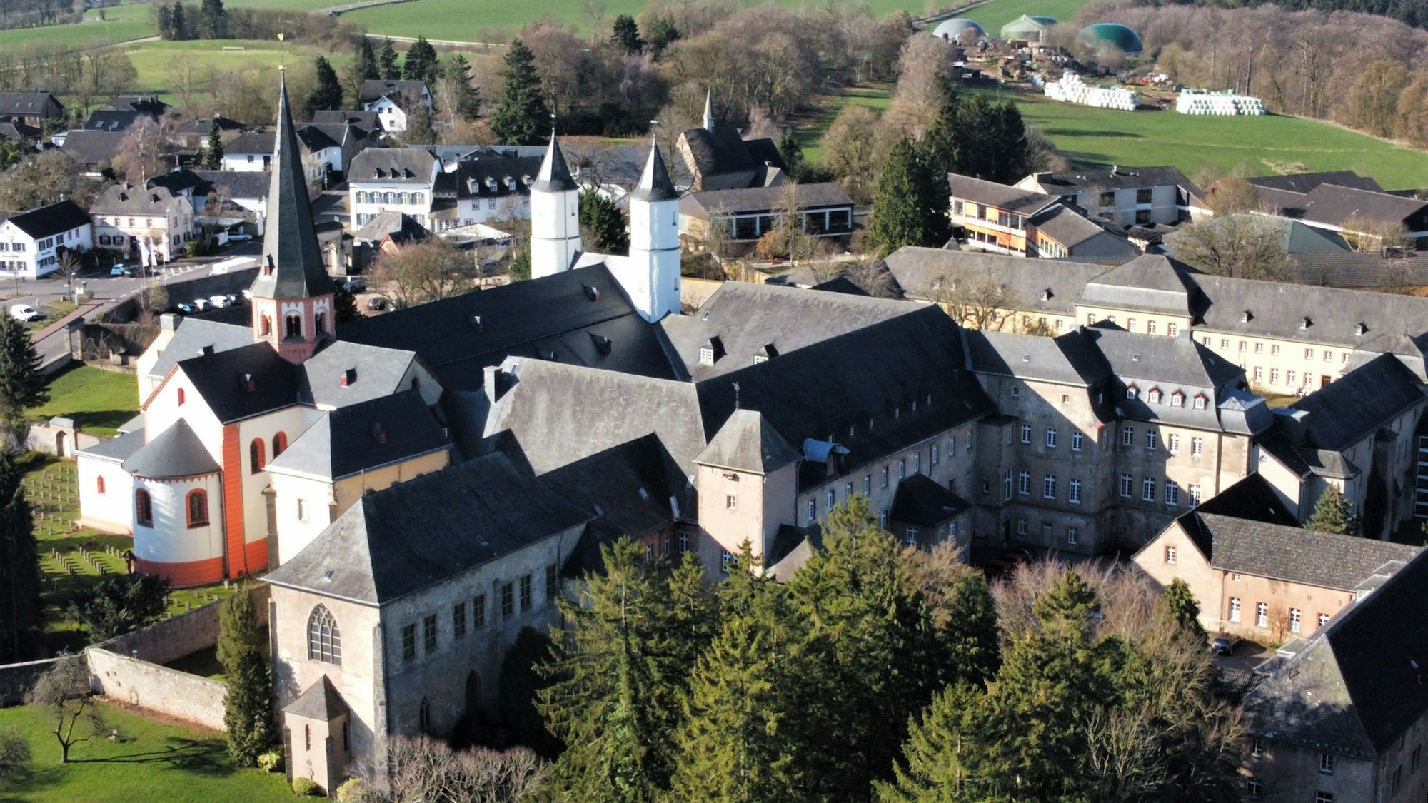 Das Luftbild zeigt das Gebäudeensemble des Klosters in Steinfeld. Im linken Bereich ist die Basilika mit ihren Türmen zu sehen.
