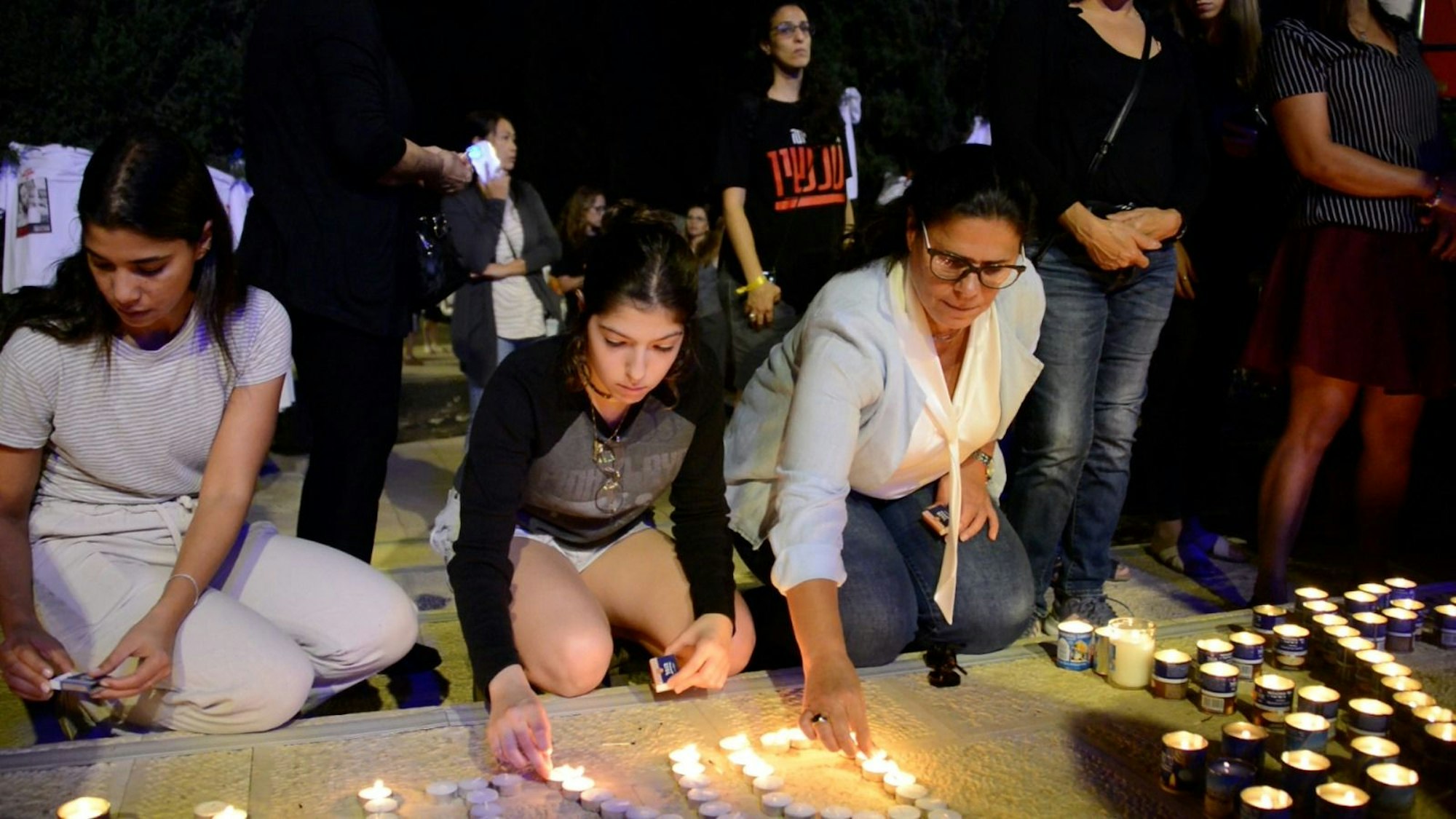 Menschen zünden Kerzen an.