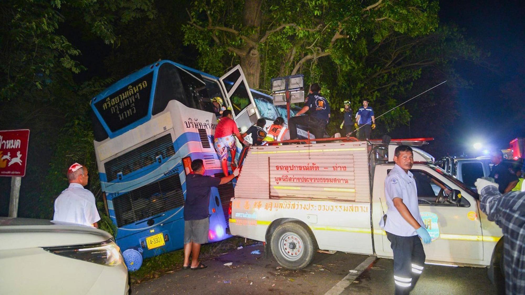 In this photo provided by Sawang Rungrueang Rescue22 Foundation, rescue workers and volunteers work at the site of a bus accident Tuesday, Dec 5, 2023, at the Prachuap Khiri Khan province, Thailand. A dozen of people were killed after the vehicle fell off the road and hit a big tree.(Sawang Rungrueang Rescue22 Foundation via AP)