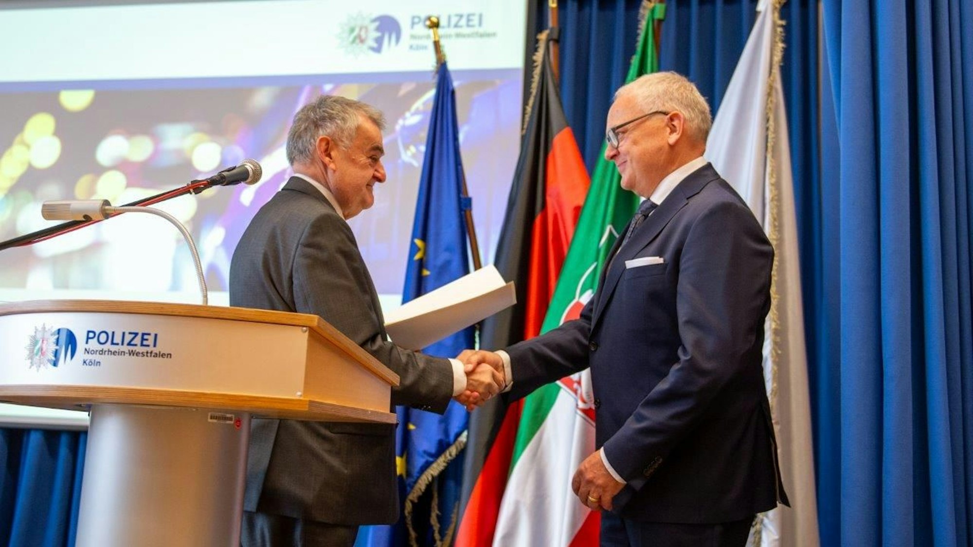 Innenminister Reul schüttelt Polizeipräsident Johannes Hermanns die Hand.