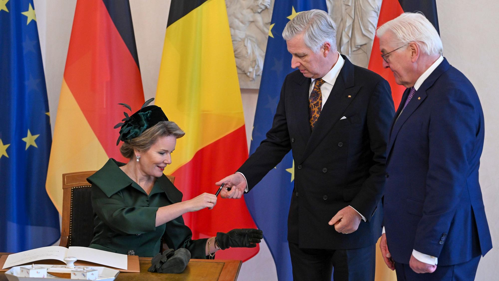Das belgische Königspaar König Philippe (m.) und Königin Mathilde tragen sich in das Gästebuch im Schloss Bellevue ein, während Bundespräsident Frank-Walter Steinmeier neben ihnen steht.