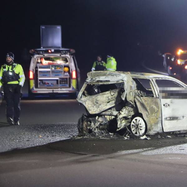 Einsatzkräfte stehen in der Nacht auf der Autobahn in der Nähe eines ausgebrannten VW-Polos. Die Autobahn, auf der der Wagen steht, ist komplett gesperrt.