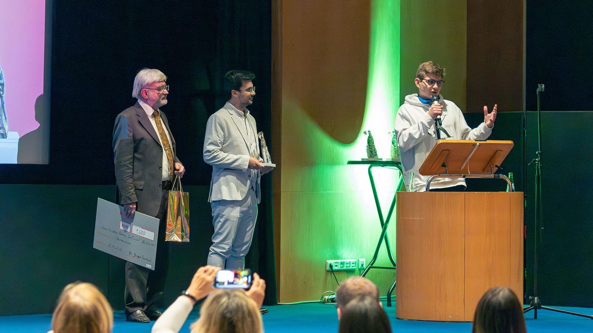 Publikumspreisträger Aaron am Mikro. Daneben stehen Dr. Rembold (links) und Üwen Ergün (Mitte)