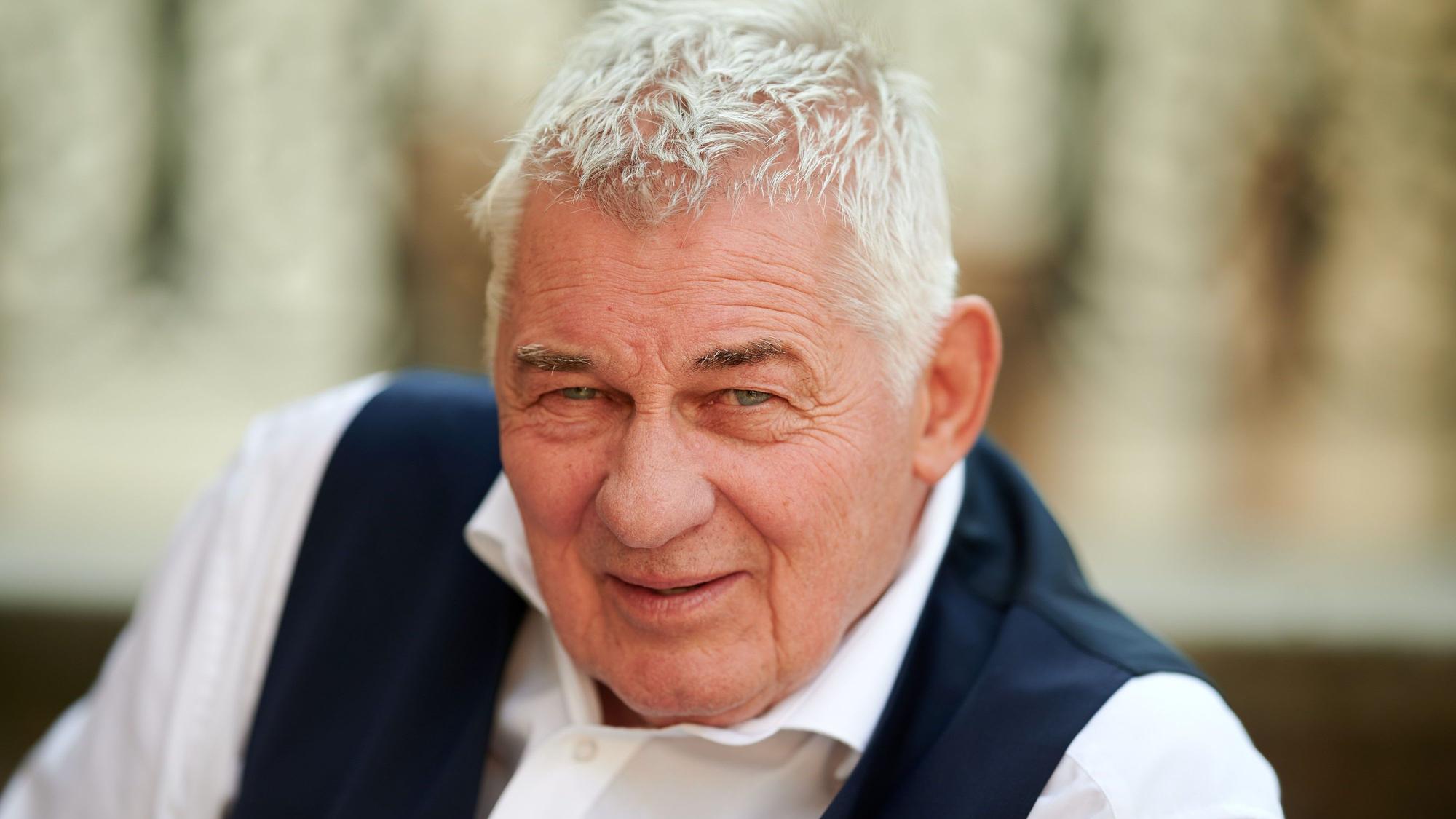 Der Schauspieler Heinz Hoenig sitzt bei einem Fototermin bei Dreharbeiten zur TVNOW Serie "Verbotene Liebe - Next Generation" auf einer Treppe.