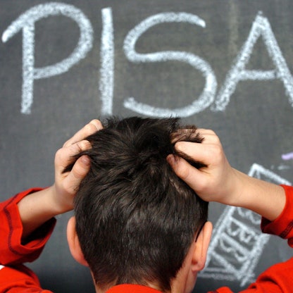 Ein Schüler rauft sich in vor dem mit Kreide an eine Schultafel geschriebenen Wort PISA die Haare. Das Ergebnis des Pisa-Test fiel schlecht aus