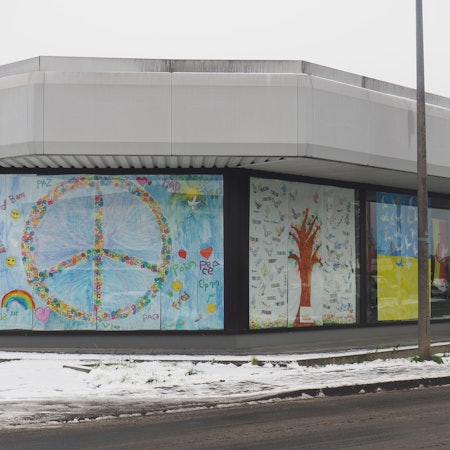 Ein großes Plakat mit dem Peace-Zeichen verdeckt ein Schaufenster.