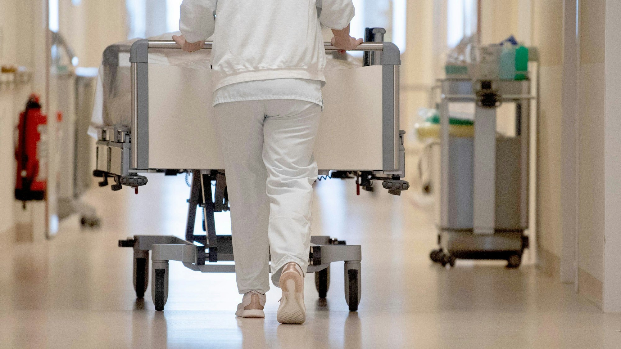 ARCHIV - 20.01.2020, ---: Eine Krankenpflegerin schiebt ein Krankenbett durch einen Flur. Am Donnerstag (05.01.2023) berät die Bund-Länder-Arbeitsgruppe über die Umsetzung der Reformvorschläge zur Krankenhausfinanzierung, die von einer für das Thema eingesetzten Expertenkommission am 6. Dezember vorgestellt wurden. Foto: Marijan Murat/dpa +++ dpa-Bildfunk +++