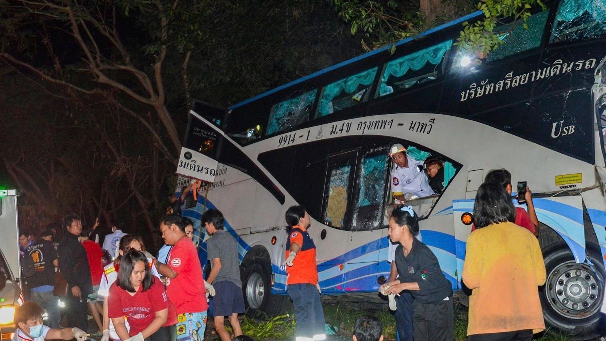 In this photo provided by Sawang Rungrueang Rescue22 Foundation, rescue workers and volunteers work at the site of a bus accident Tuesday, Dec 5, 2023, at the Prachuap Khiri Khan province, Thailand. A dozen of people were killed after the vehicle fell off the road and hit a big tree.(Sawang Rungrueang Rescue22 Foundation via AP)