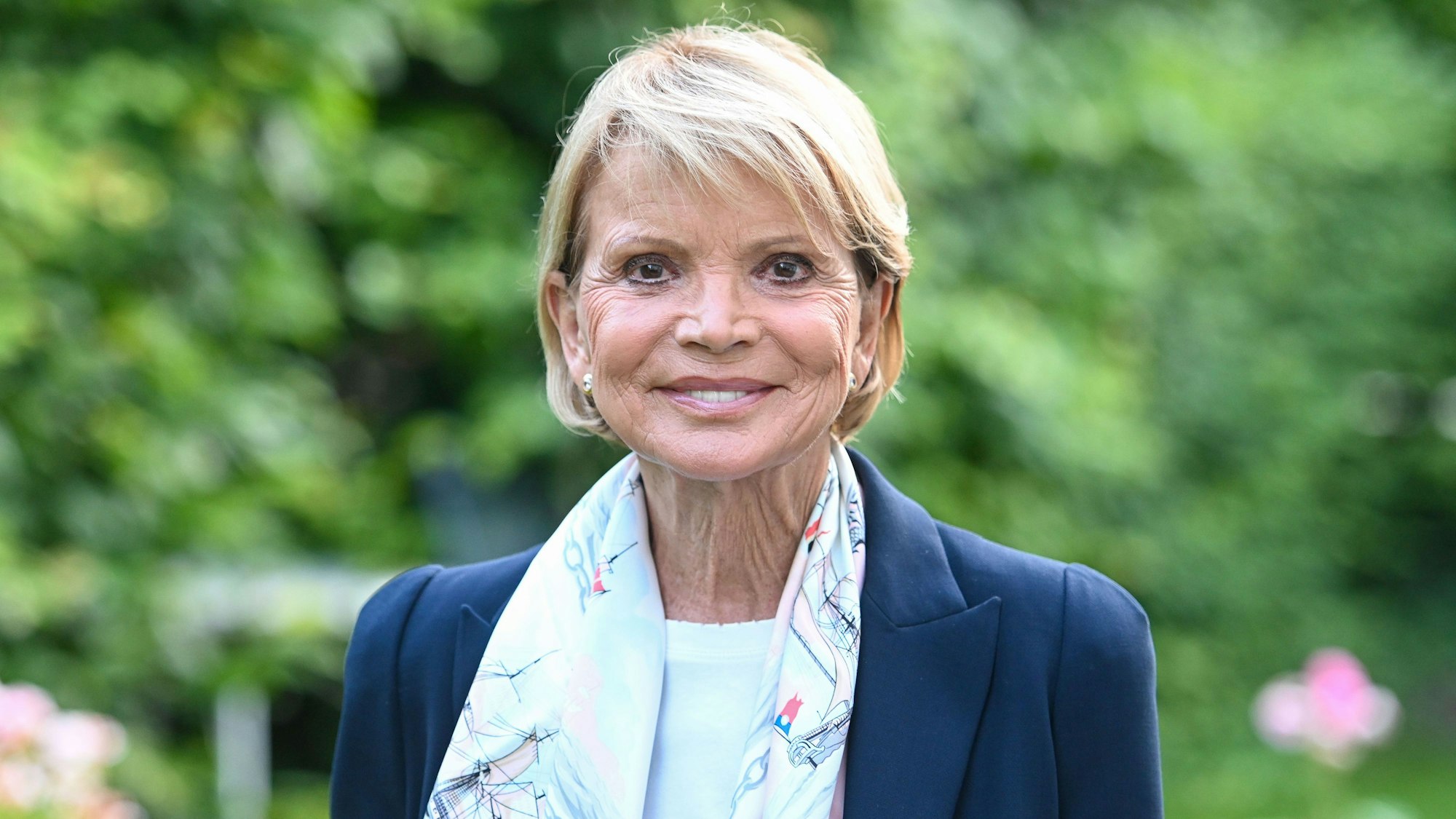 Uschi Glas in einem Garten.