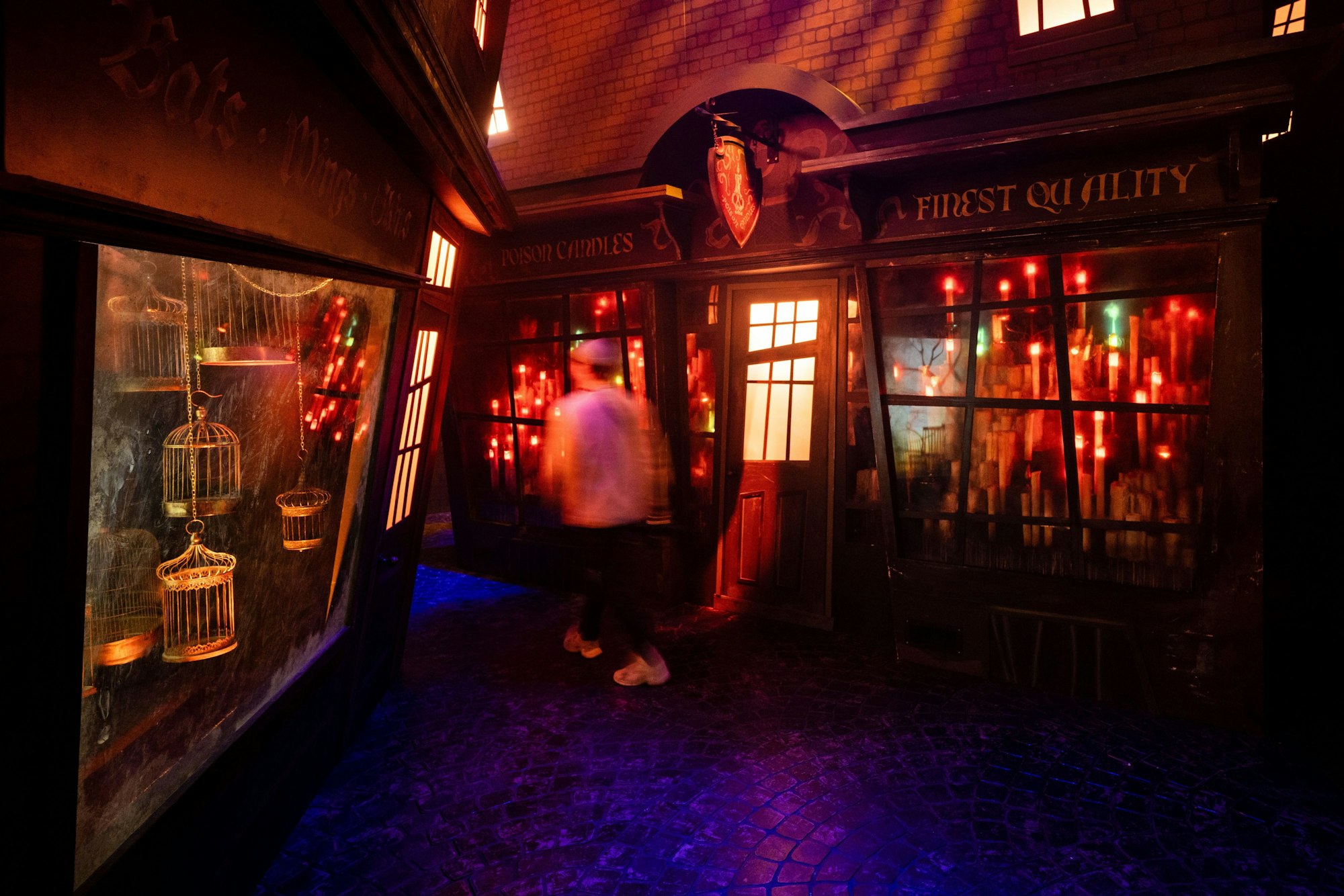 Ein Mann geht durch eine enge, dunkle Gasse, an den Seiten sind Schaufenster zu erkennen.