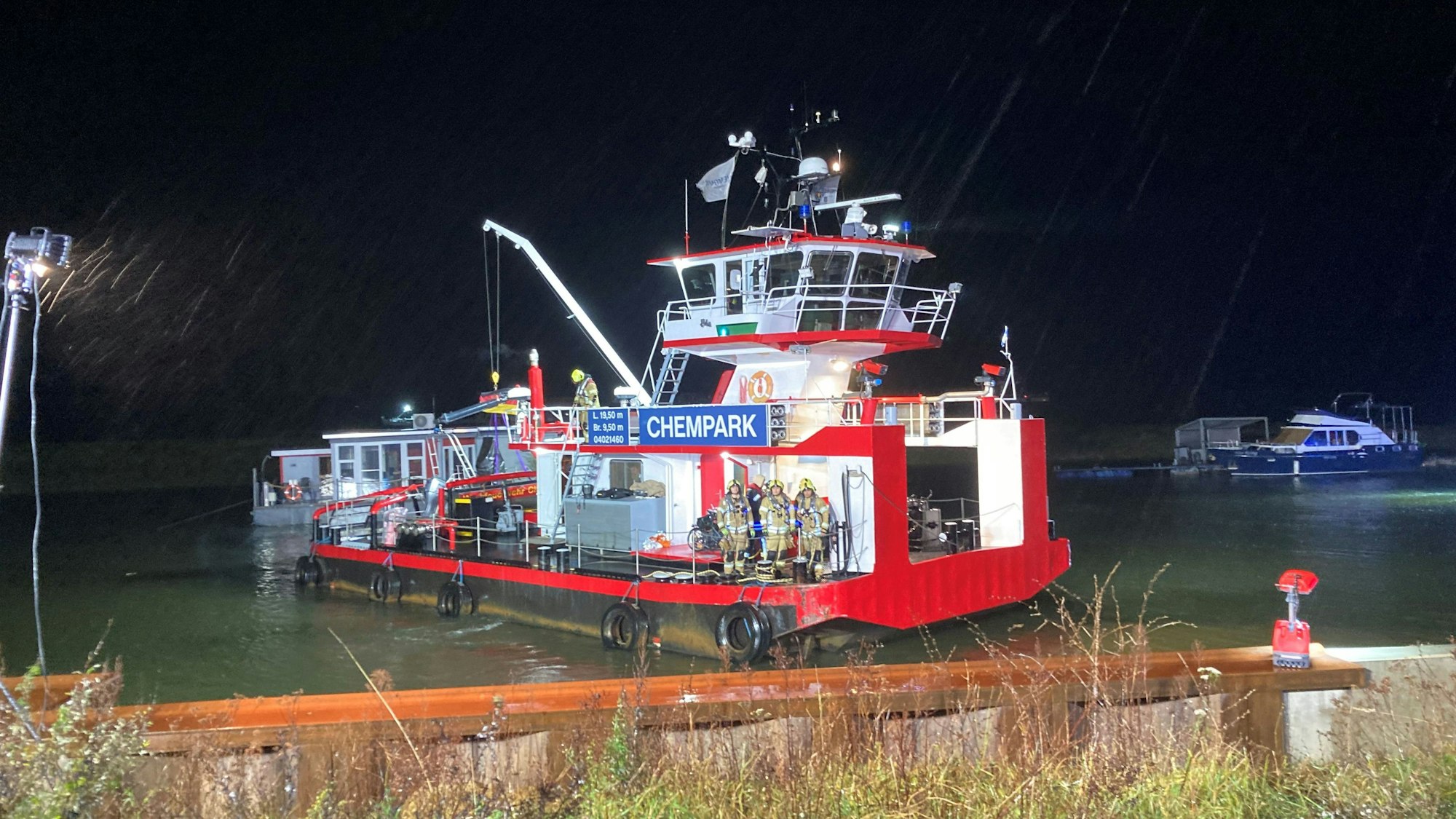 Zu sehen ist ein Schiff mit der Aufschrift „Chempark“ während der Bergung von Passagieren auf dem Rhein. Es ist dunkel.
