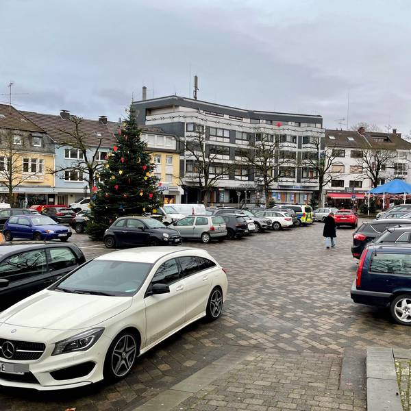 Autos parken auf einer gepflasterten Fläche.