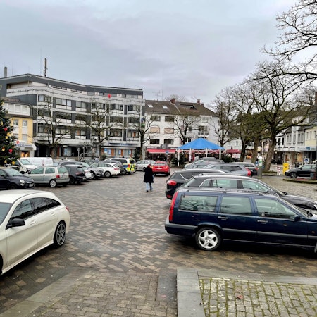 Autos parken auf einer gepflasterten Fläche.