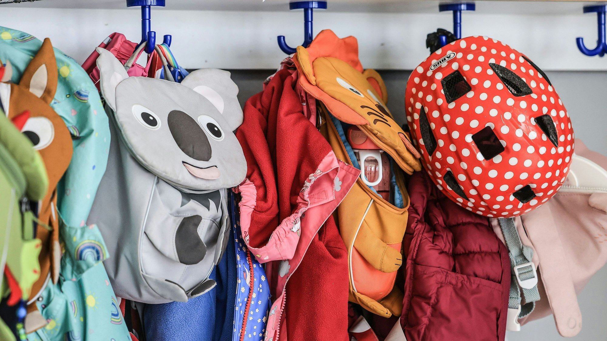 Garderobe und Taschen von Kindern hängen im Flur einer Kindertagesstätte.
