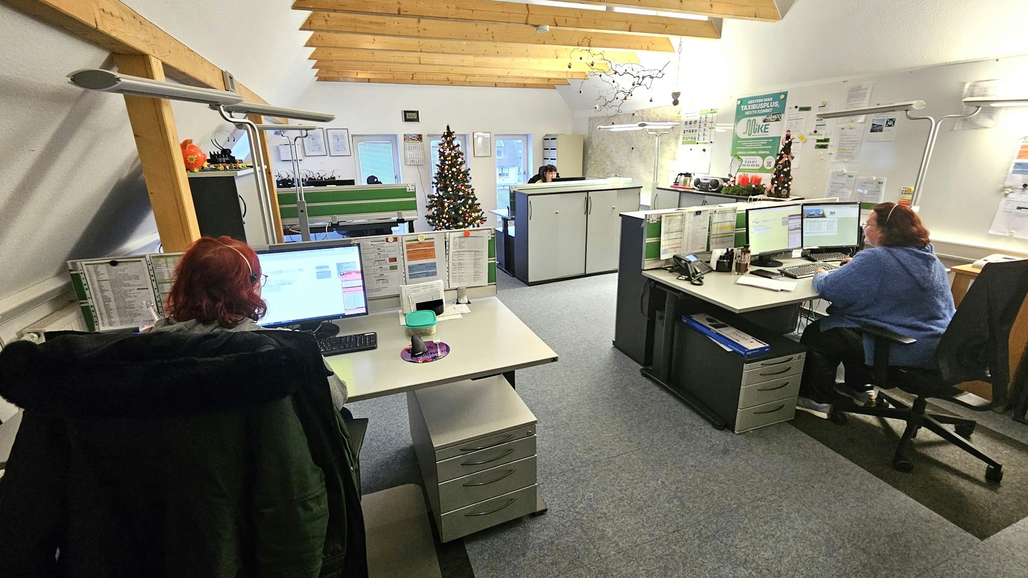 Blick in die Zentrale für den Taxi-Bus. Mehrere Mitarbeitern sitzen vor Computern.