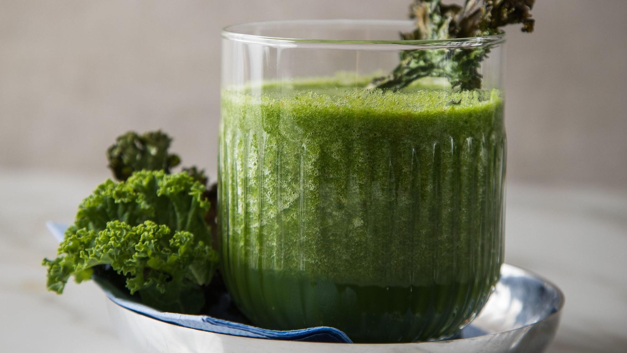 Ein grüner Smoothie mit grünem Gemüse ist in einem Glas in einer Schale angerichtet. (Symbolbild)