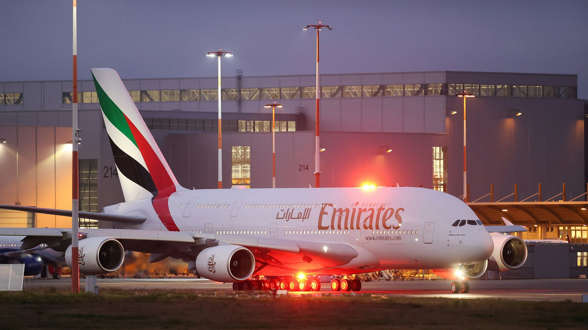 Ein Airbus A380 der arabischen Fluggesellschaft Emirates rollt neben zahlreichen Warnleuchten über eine Landebahn. (Symbolbild)