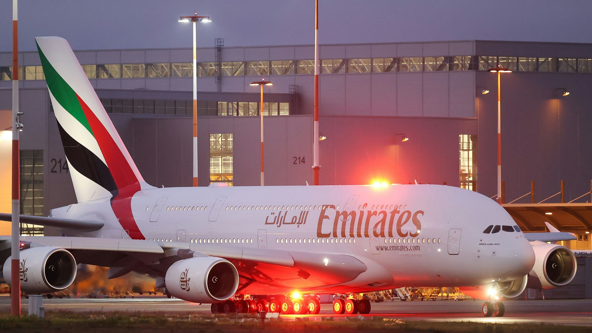 Ein Airbus A380 der arabischen Fluggesellschaft Emirates steht an einem Rollfeld vor einem roten Warnlicht. (Symbolbild)