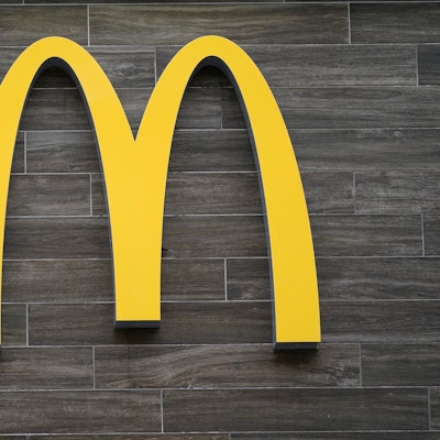 Ein goldenes M hängt an einer Wand.