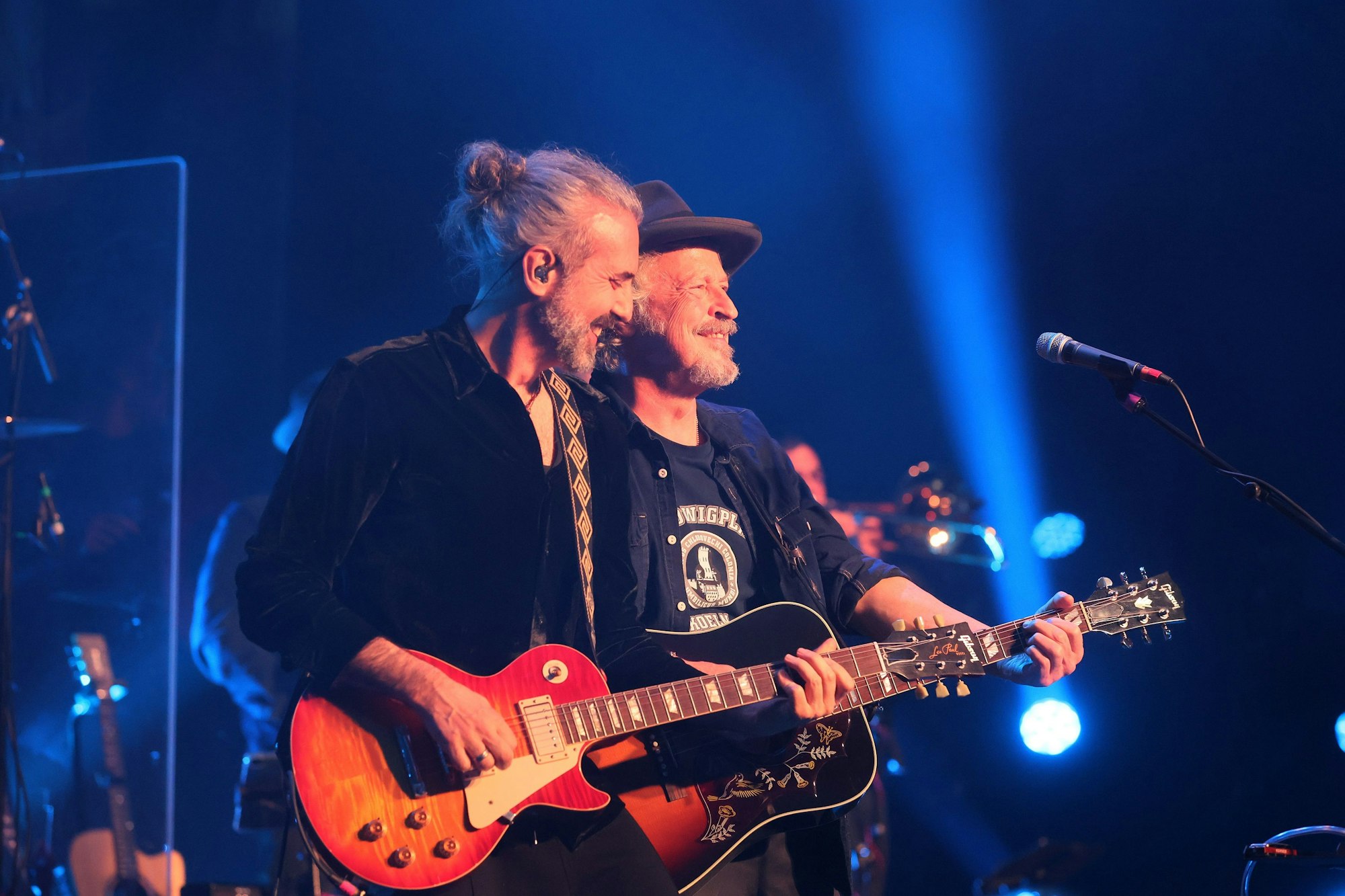 Rode und Niedecken stehen nebeneinander auf der Bühne und spielen Gitarre.