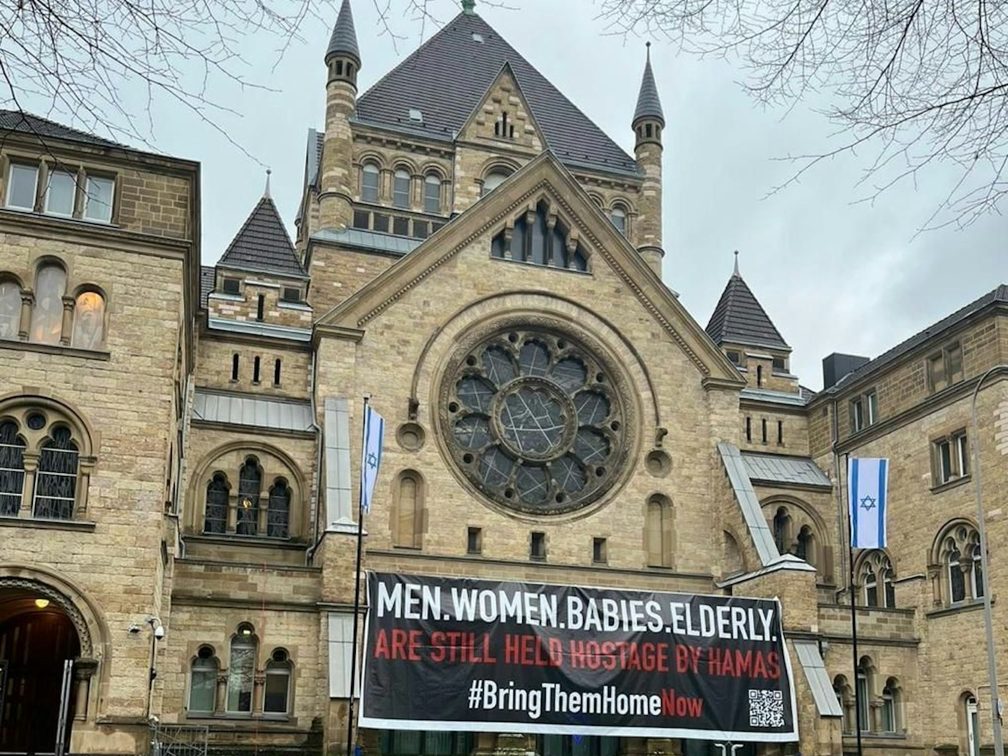 „Bring them home now“ ist auf einem Banner vor der Synagoge an der Ronnstraße zu lesen.