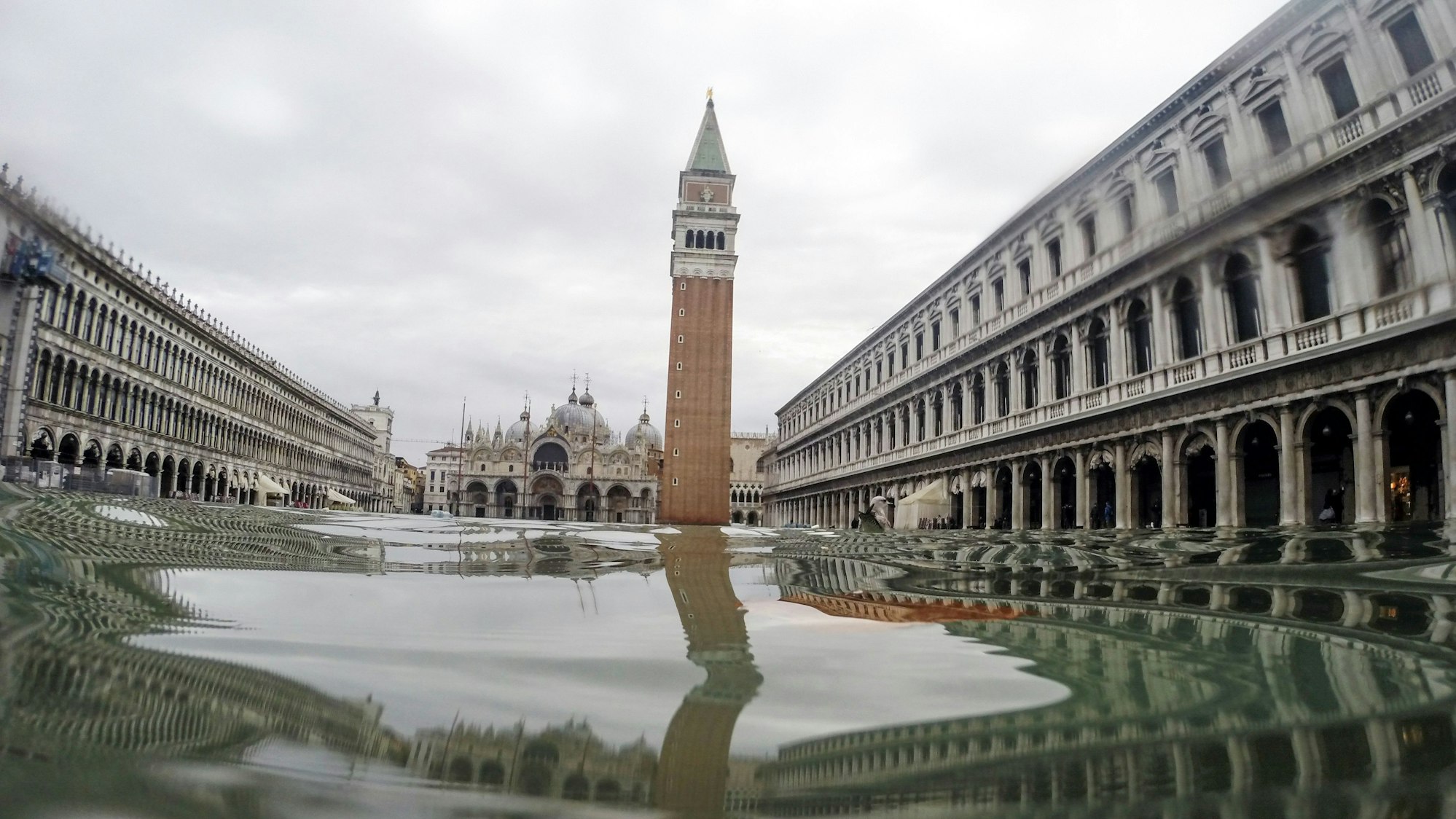 Der Markusturm spiegelt sich im Hochwasser, das den Markusplatz bedeckt.