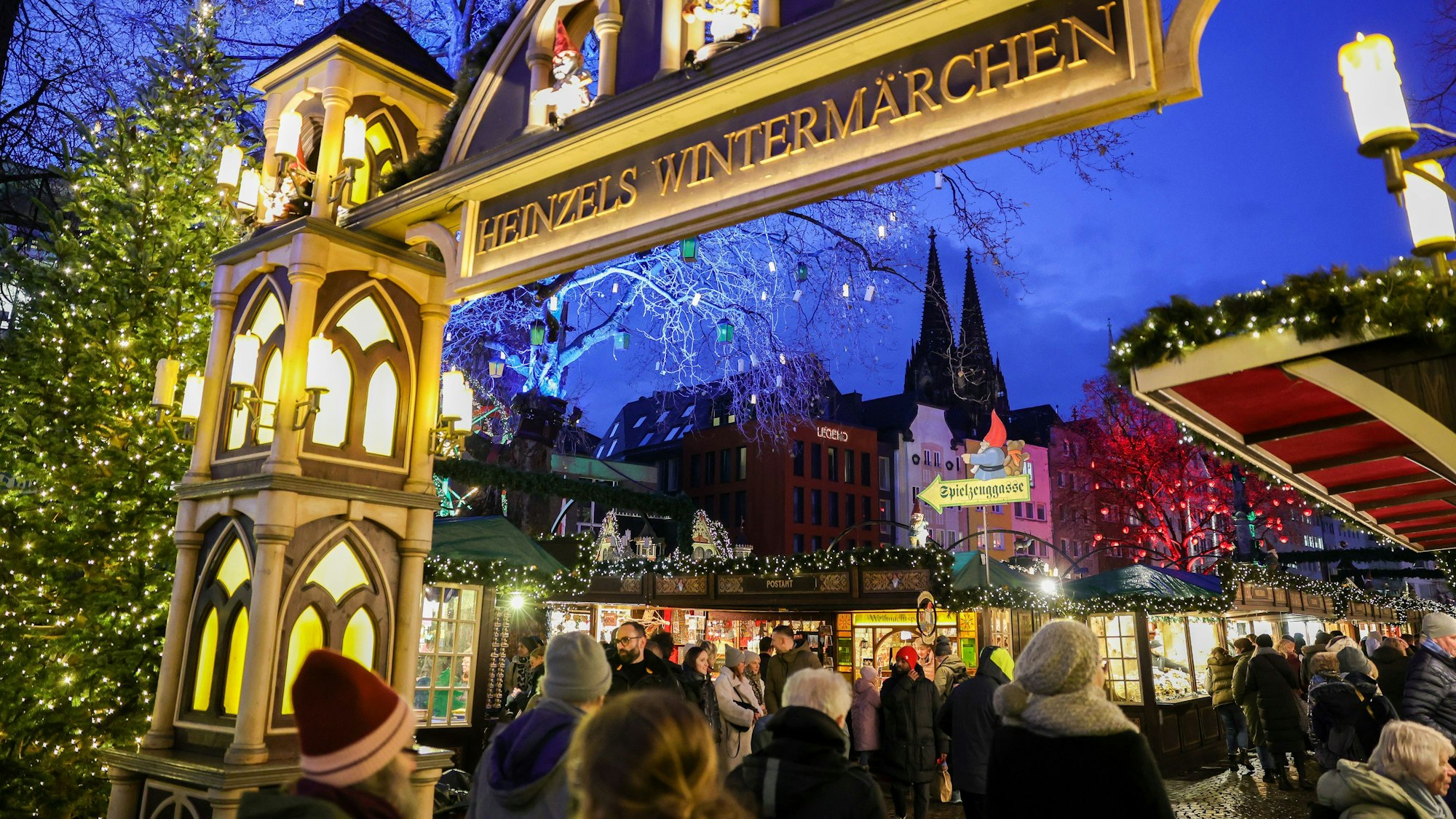 Der Weihnachtsmarkt auf dem Heumarkt und Alter Markt am Abend mit leuchtenden Lichtern und Blick auf den Dom. (Archivbild)