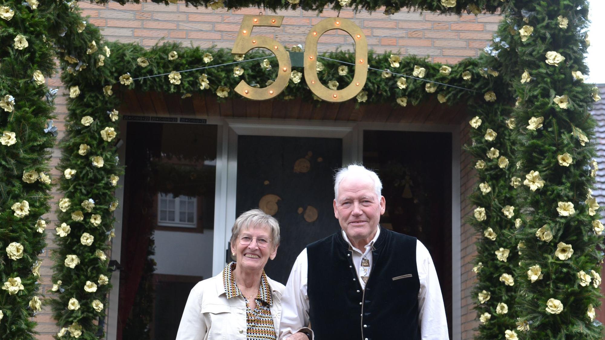 Maria und Franz-Josef Breuer aus Zülpich stehen vor einem geschmückten Hauseingang. Über dem Eingang prangt die Zahl 50.