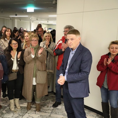 Kreisdirektor Dr. Erik Werdel steht im Foyer des Kreishauses Am Rübezahlwald. Menschen applaudieren ihm.