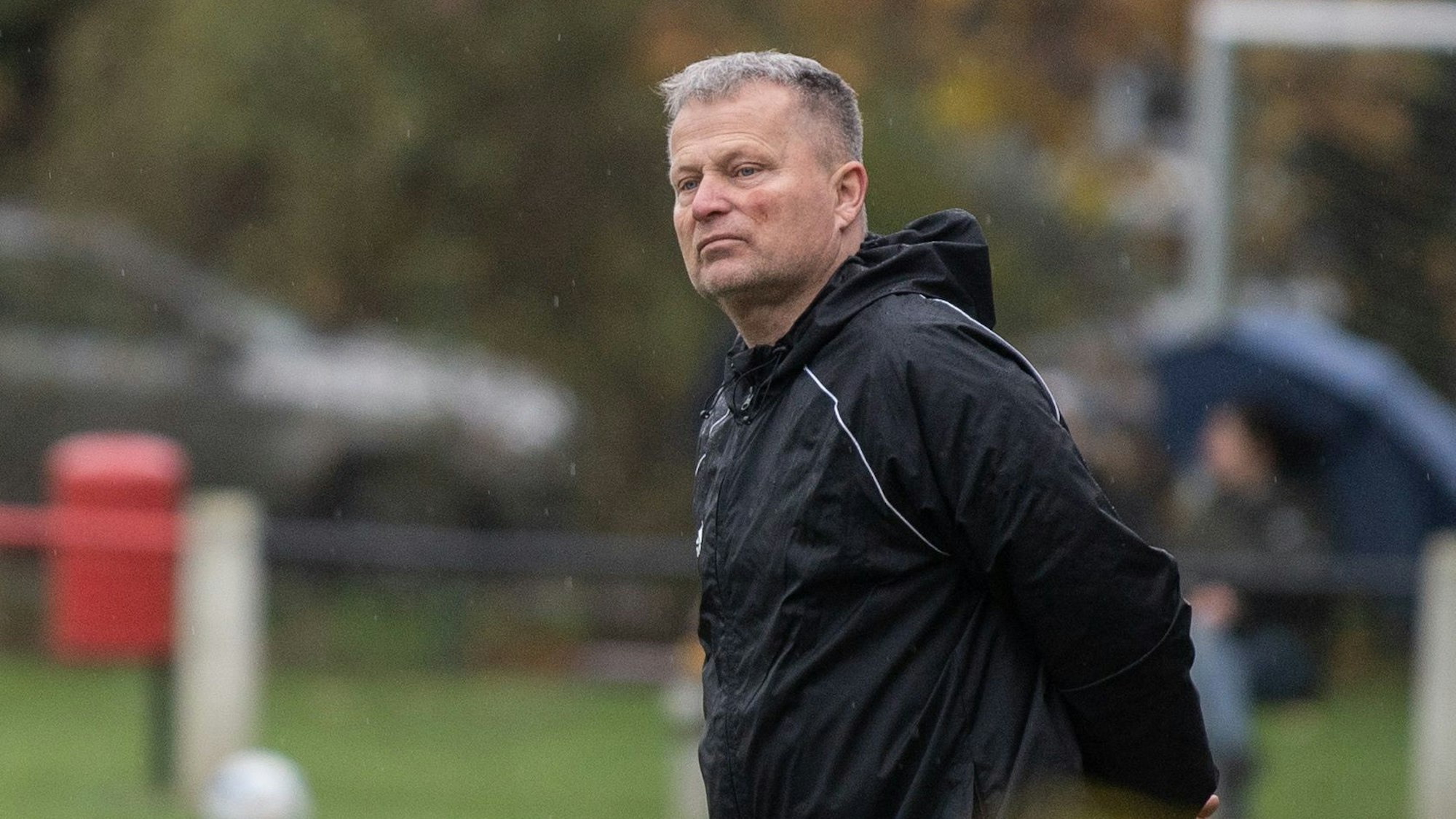 Axel Sendscheid, Trainer des TB-SV Füssenich-Geich, beobachtet mit hinter dem Rücken verschränkten Händen ein Spiel seiner Mannschaft.
