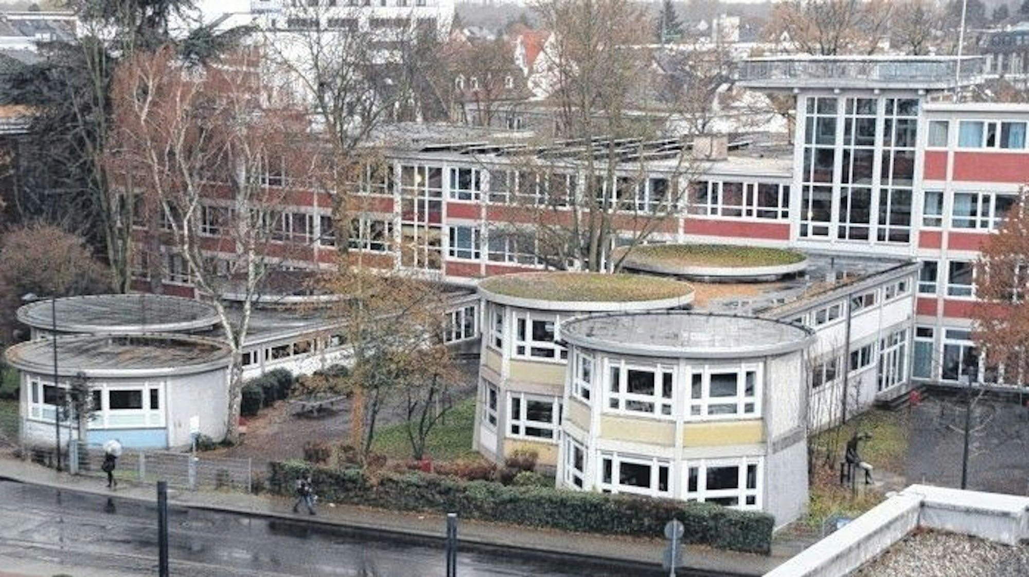 Eine Schule mit pavillonförmigen Trakten und Fassadenelementen in Pastelltönen Gelb, Rot und Hellblau