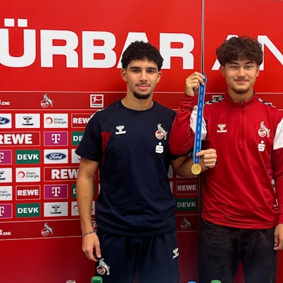 Die FC-Spieler Fayssal Harchaoui (li.) und Justin von der Hitz präsentieren am Geißbockheim stolz die Goldmedaille für den WM-Titel mit der deutschen U17-Nationalmannschaft. Doch wo ist die zweite?