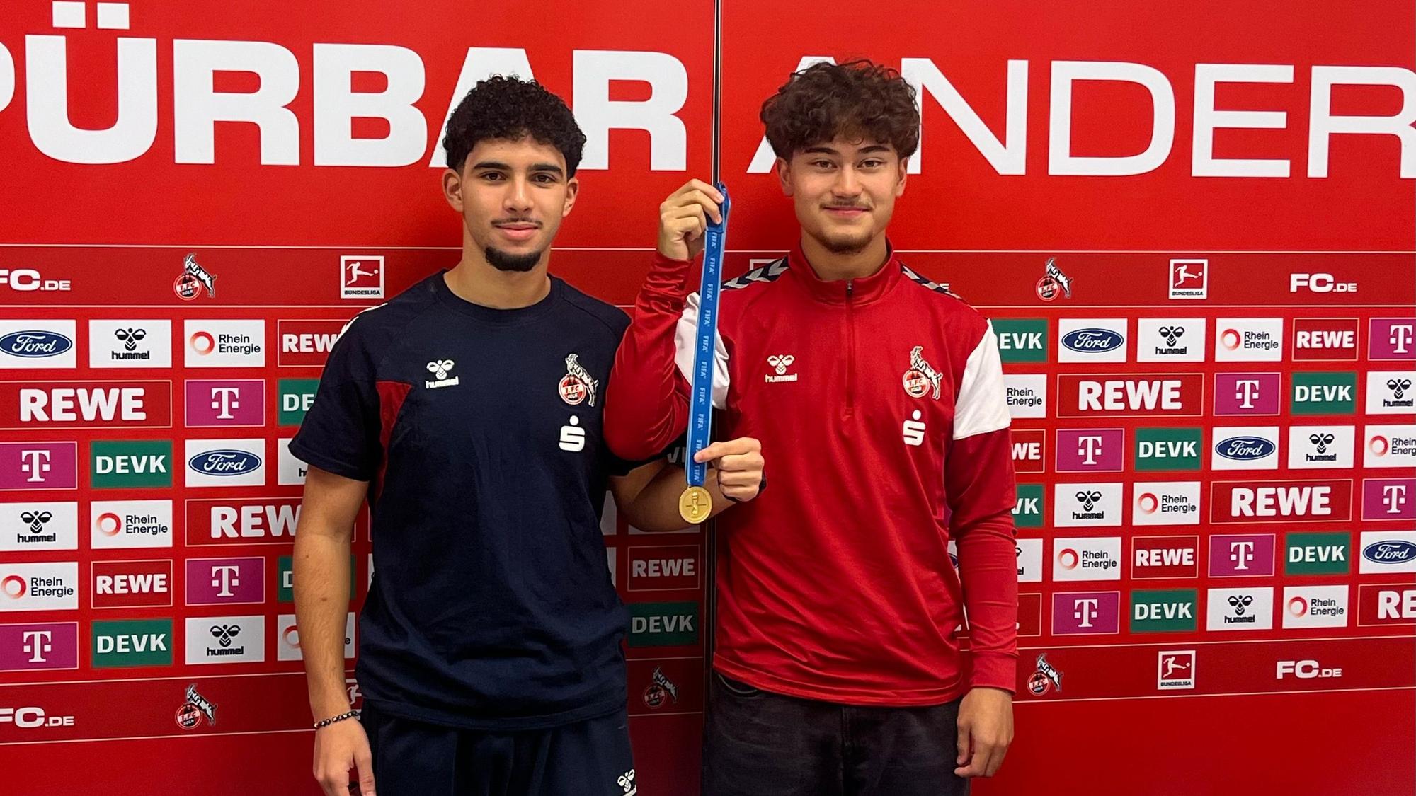 Die FC-Spieler Fayssal Harchaoui (li.) und Justin von der Hitz präsentieren am Geißbockheim stolz die Goldmedaille für den WM-Titel mit der deutschen U17-Nationalmannschaft. Doch wo ist die zweite?