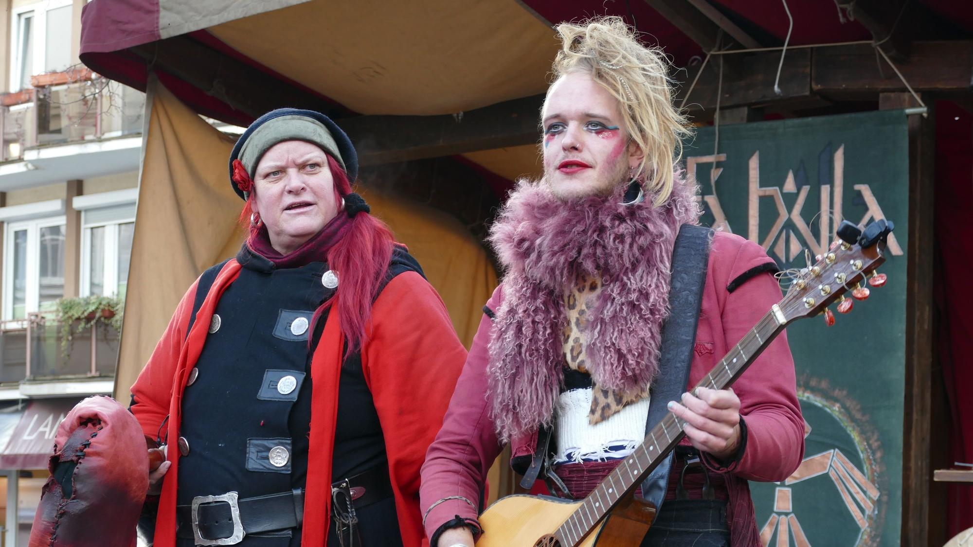 Ein Mann und eine Frau in mittelalterlicher Tracht spielen auf Instrumenten.