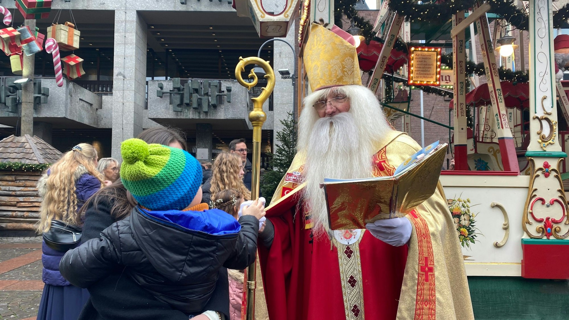 Zu sehen ist Wolfgang Kimmig-Liebe mit Kindern auf dem Weihnachtsmarkt.