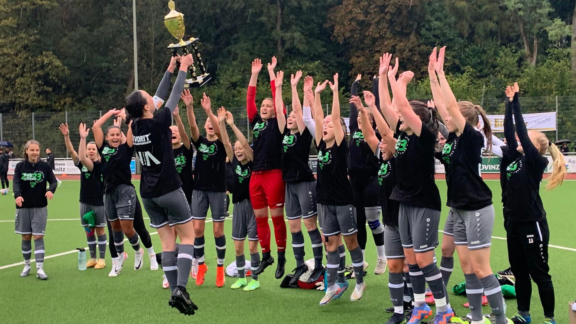 Nach dem Gewinn des Kreispokals feiern die Fußballerinnen des TuS Homburg-Bröltal springend mit dem Pokal.