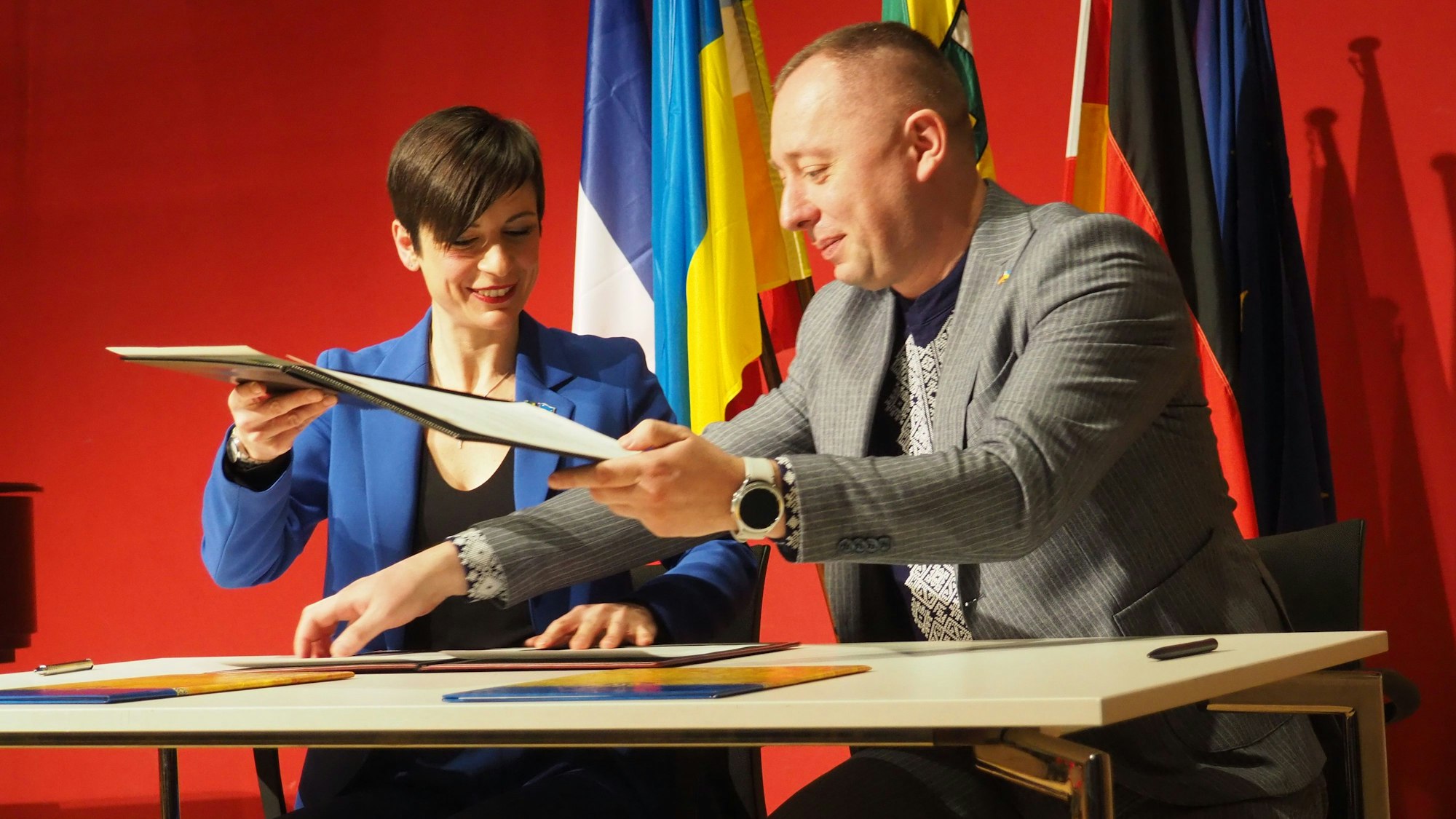 Carolin Weitzel und Igotr Hirchak unterzeichnen ein Dokument.